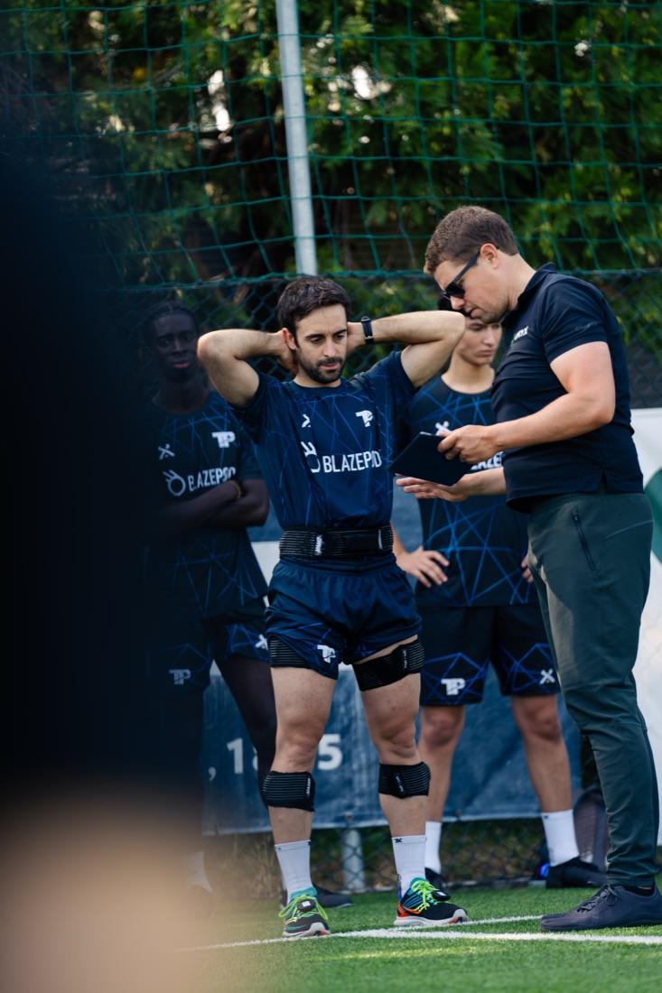 Marcel bespreekt een meting met een sporter op het veld